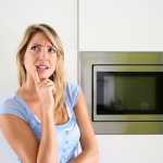 lady thinking next to a microwave