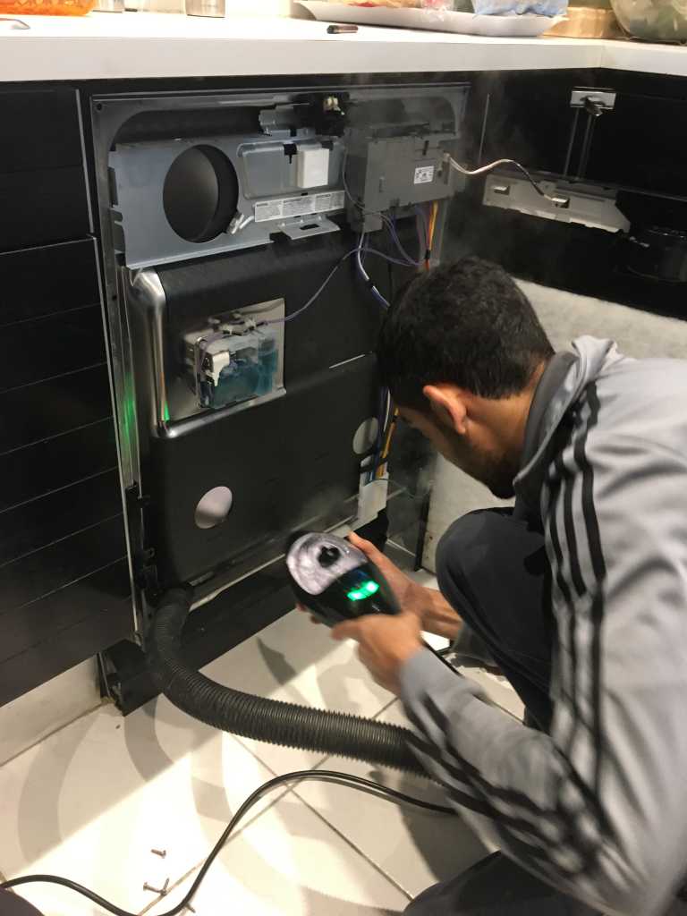 a technician fixing a dishwasher appliance