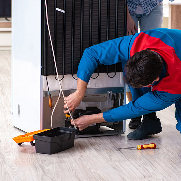 fridge repair technician fixing a refidgerator